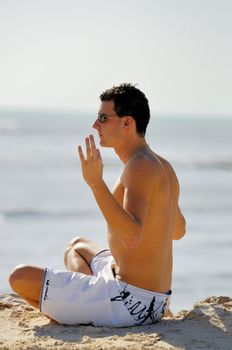 Man doing yoga on the beach