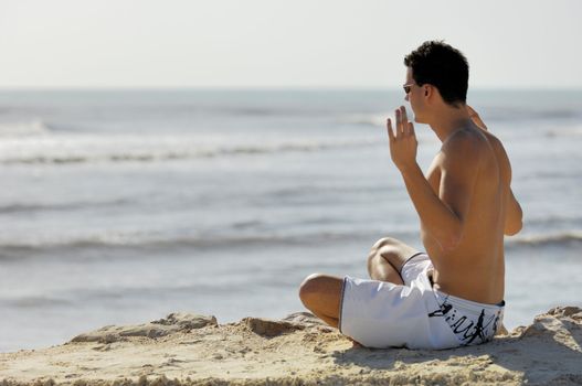 Man doing yoga on the beach