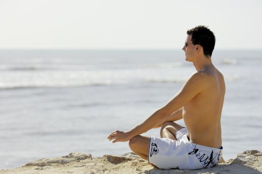 Man doing yoga on the beach