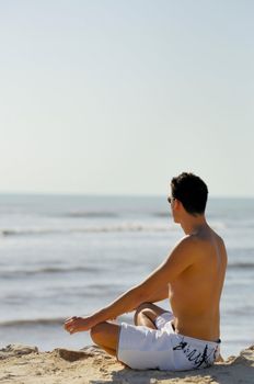 Man doing yoga on the beach