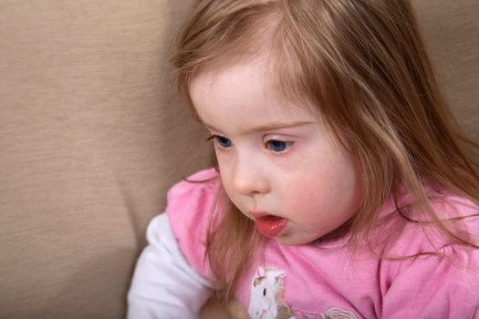 Portrait of little handicapped caucasian girl with Down Syndrome