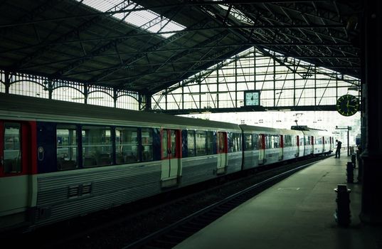 Lonely person waiting for a train at large station