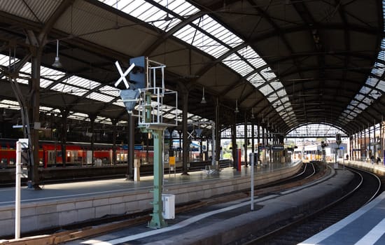 Railway station in bright sunny day, passengers waiting for train