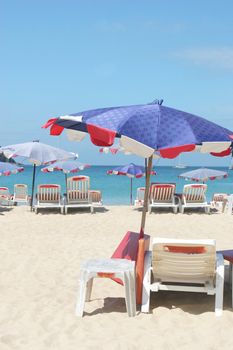 Rows of colorful beach chairs and umbrellas at the beach.