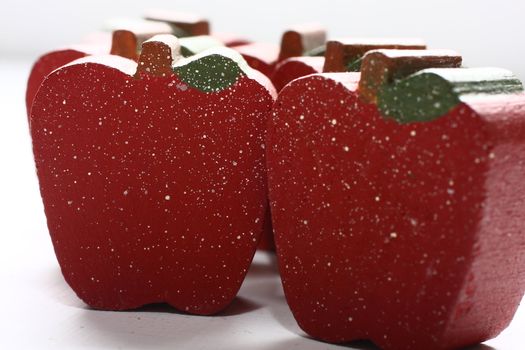 Red painted wooden apples with white splatter.