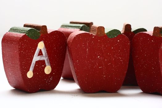 Wooden Apples with the letter "A" painted on it.