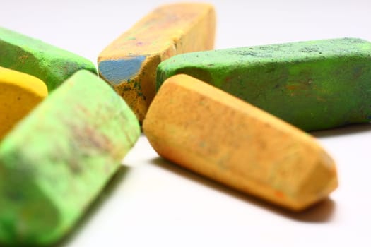 A few used yellow and green chalk pastels on white