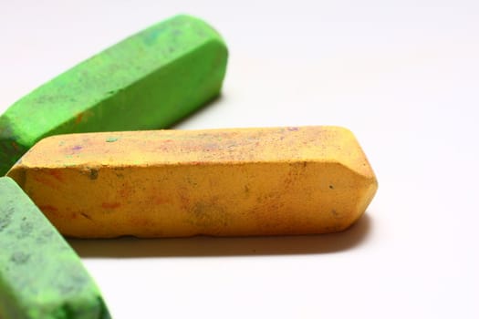 A few used yellow and green chalk pastels on white