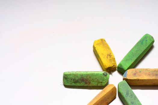 A few used yellow and green chalk pastels on white