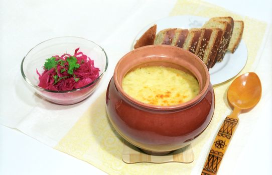 Soup in casserole with appetizer and bread
