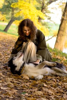 Lady in medieval dress and dog in the forest
