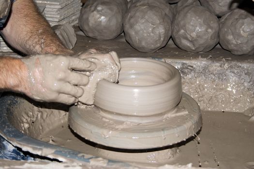 A potter creating a dish on his potters wheel