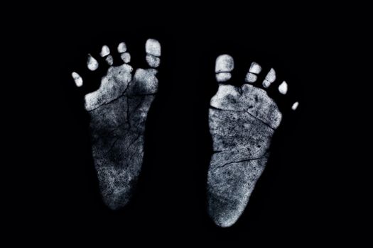 Newborn's feetprint on black