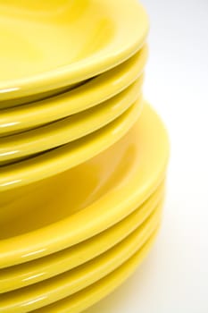 Stack of yellow plates isolated on white background.