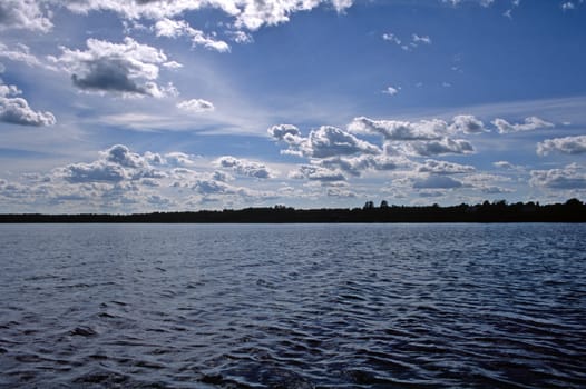 Summer lake with deep blue sky and white clouds