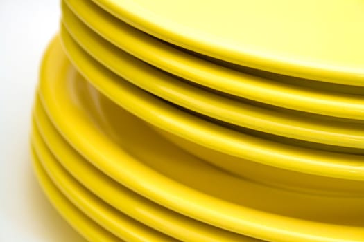 Stack of yellow plates isolated on white background.