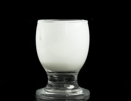 Glass with milk on a black background