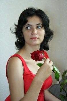 The beautiful girl holds a scarlet rose