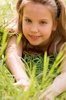 Young girl is laying down in the grass