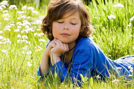 Young boy is thinking in the grass