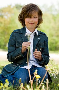 yoiung child is checking out a flower