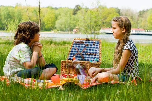 Two children enjoying a picnic in the summer
