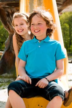 Two happy children playing on the playgroundr