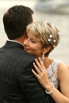 The bride with a smile, gently embraces the groom