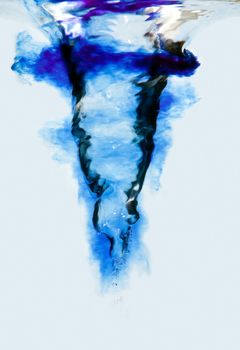 Side view of an underwater vortex swirl with bubbles and blue ink clouds, isolated