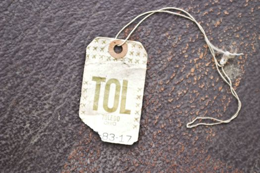Vintage airline luggage tag on an antique suitcase. Toledo, OH wrote on the tag.