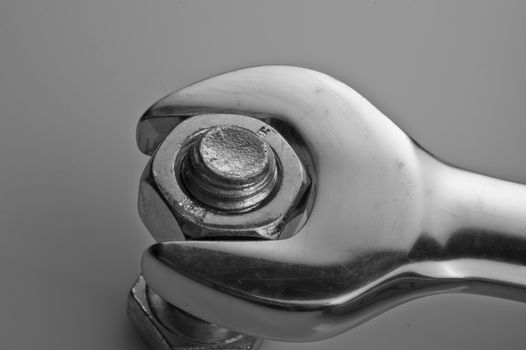 Close up of a wrench either loosening or tightening a nut from a bolt