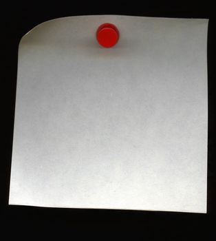 Extreme close up of a paper pinned by a red pushpin