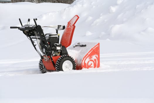 Snow blower in the snow clearing out a path