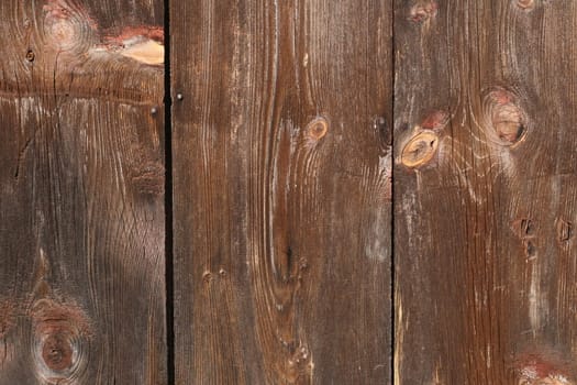 a panel of old wood siding, showing age and pattern, knotholes, vertical 