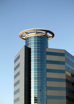 a tall modern city building,showing many windows, against a blue sky