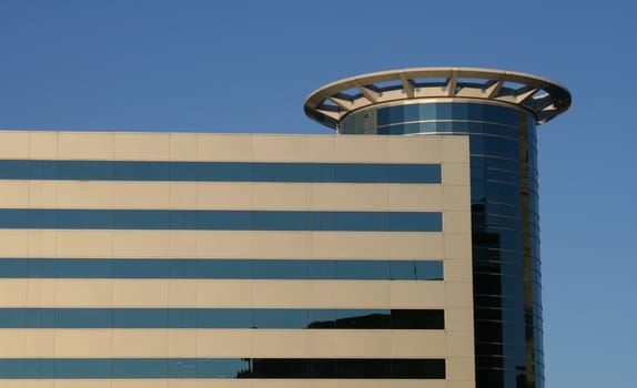 a linear view of a modern building with rows of windows, against a blue sky