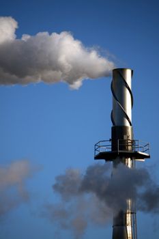 a tall smokestack at an industrial factory, spewing smoke and pollution