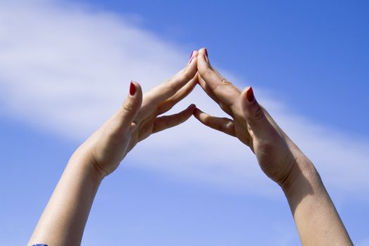 Woman hands making roof at the ear