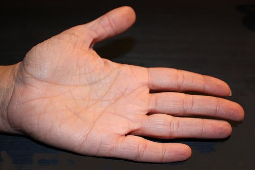 the inside of a hand with deep lines on a black background