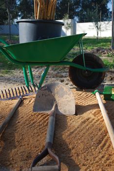 different tools for agriculture (wheelbarrow, shovel, rake)