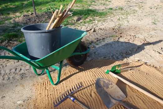 different tools for agriculture (wheelbarrow, shovel, rake)