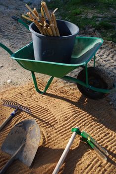 different tools for agriculture (wheelbarrow, shovel, rake)