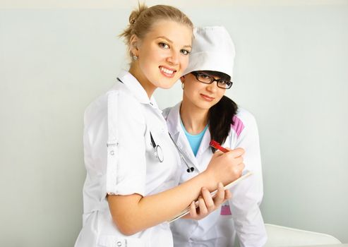 portrait of a young doctor with her assistant in the office
