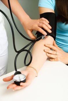 closeup of the hands of a doctor measuring  blood pressure of a patient 