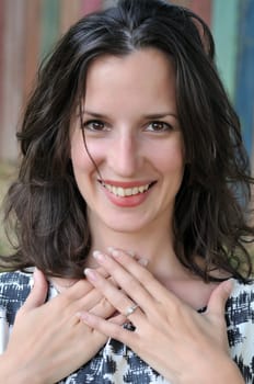 Young, attractive woman looks pleased and surprised about her new engagement ring.