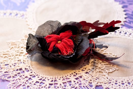 black and red artificial handmade flowers on white napkins
