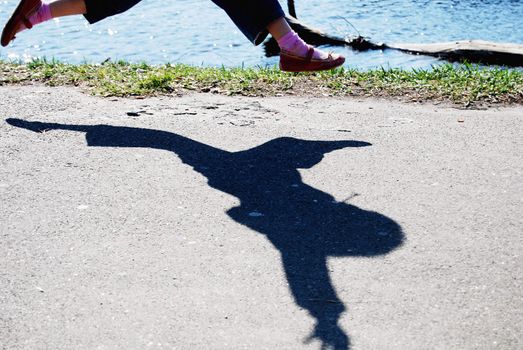 shadow of jumping figure with hands up