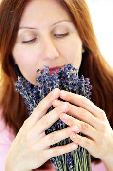 Mature woman smelling lavender flowers focus on hands