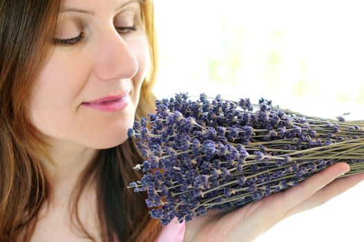 Mature woman smelling bunch of dried lavender