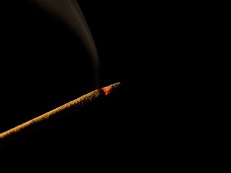 Closeup of an incense stick isolated on black